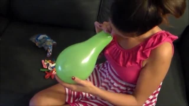 Yesenia blows balloons and pops them with her nails